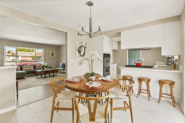 2406 S Pacific Ave, Santa Ana, CA 92704 - dining room featuring light tile patterned floors and a chandelier