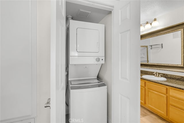 2275 Del Mar Way Unit 307, Corona, CA 92882 - laundry room featuring stacked washer / dryer and light tile patterned floors