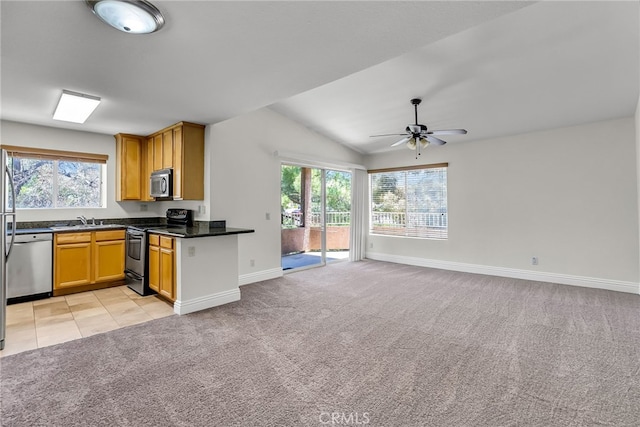 2275 Del Mar Way Unit 307, Corona, CA 92882 - kitchen featuring appliances with stainless steel finishes, open floor plan, light carpet, a ceiling fan, and healthy amount of natural light