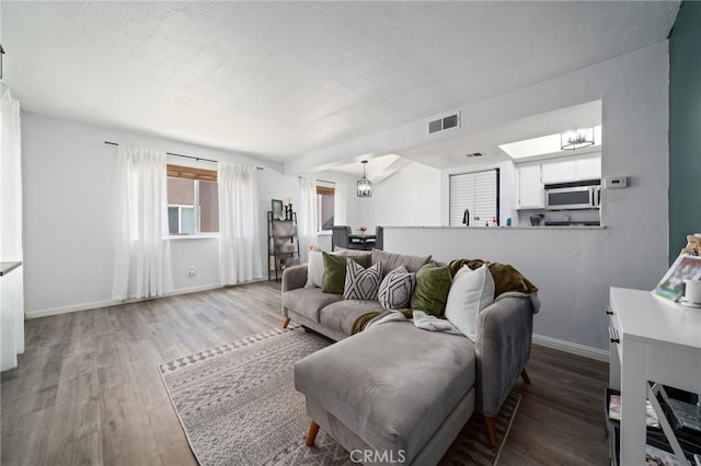3051 Knollwood Ave, La Verne, CA 91750 - living room featuring wood finished floors, a chandelier, and a skylight