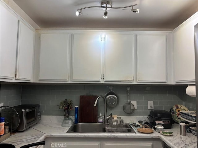 22840 Hilton Head Unit 129, Diamond Bar, CA 91765 - kitchen featuring light countertops, white cabinets, and decorative backsplash