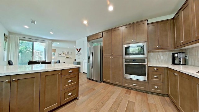 140 Unity Ln, San Marcos, CA 92078 - kitchen with stainless steel appliances, light wood finished floors, light stone counters, backsplash, and recessed lighting