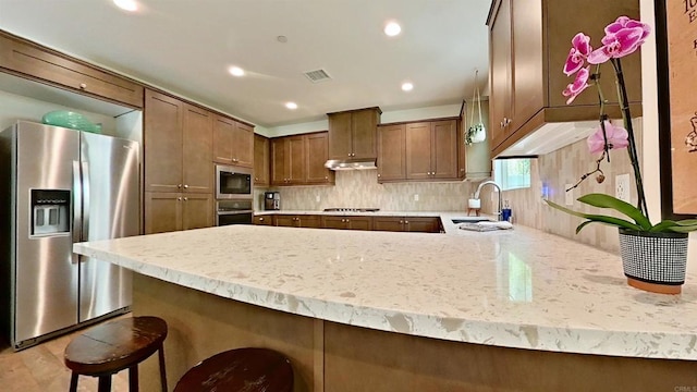 140 Unity Ln, San Marcos, CA 92078 - kitchen featuring appliances with stainless steel finishes, a peninsula, decorative backsplash, under cabinet range hood, and recessed lighting