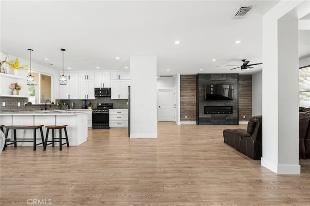 2213 De Mille Rd, Paradise, CA 95969 - kitchen featuring appliances with stainless steel finishes, open floor plan, a peninsula, a ceiling fan, and a breakfast bar area