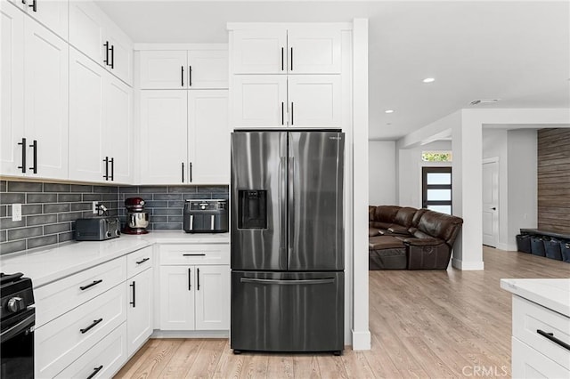 2213 De Mille Rd, Paradise, CA 95969 - kitchen with stainless steel fridge with ice dispenser, decorative backsplash, light countertops, light wood-style floors, and white cabinetry