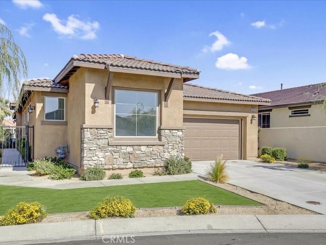 82676 Burnette Dr, Indio, CA 92201 - view of front of house with a garage, a tile roof, stone siding, concrete driveway, and stucco siding