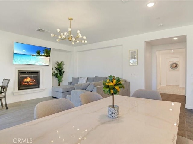 82676 Burnette Dr, Indio, CA 92201 - dining room with a chandelier, a glass covered fireplace, and recessed lighting