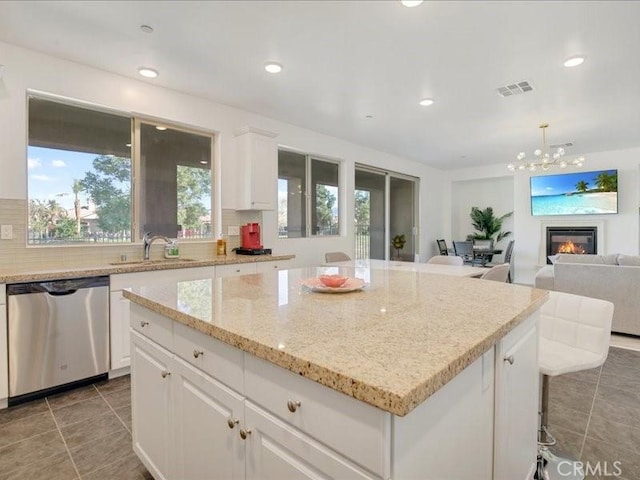 82676 Burnette Dr, Indio, CA 92201 - kitchen with dishwasher, light tile patterned flooring, a kitchen island, white cabinets, and tasteful backsplash