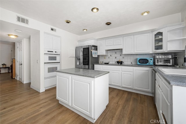 4481 Larwin Ave, Cypress, CA 90630 - kitchen featuring stainless steel appliances, white cabinets, tasteful backsplash, and wood finished floors