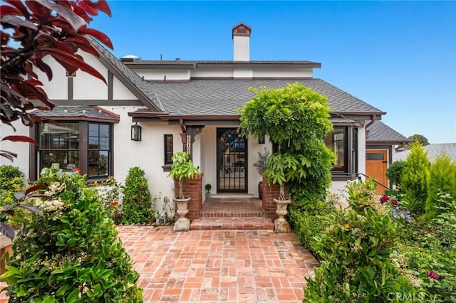 615 Seaview St, Laguna Beach, CA 92651 - doorway to property featuring stucco siding, a chimney, and a shingled roof