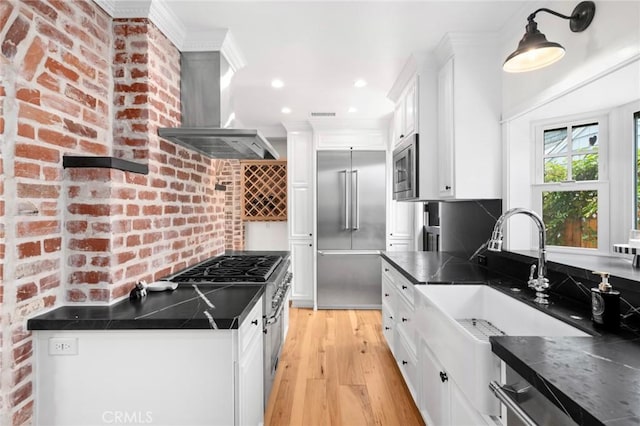 615 Seaview St, Laguna Beach, CA 92651 - kitchen with built in appliances, island exhaust hood, dark countertops, white cabinets, and light wood finished floors