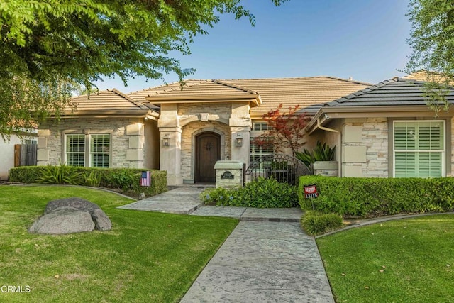 13115 Monarch Palm Ave, Bakersfield, CA 93314 - view of front of house featuring stone siding, a tiled roof, and a front yard