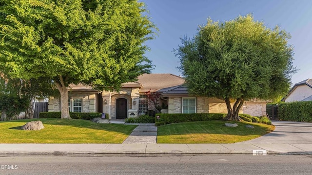 13115 Monarch Palm Ave, Bakersfield, CA 93314 - view of property hidden behind natural elements featuring stone siding and a tile roof