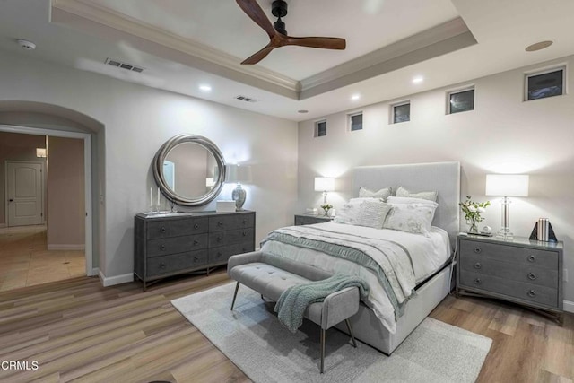 13115 Monarch Palm Ave, Bakersfield, CA 93314 - bedroom featuring a tray ceiling, crown molding, recessed lighting, light wood finished floors, and arched walkways