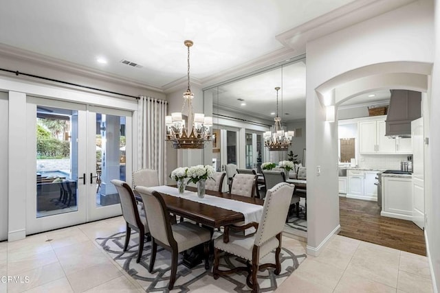 13115 Monarch Palm Ave, Bakersfield, CA 93314 - dining area featuring crown molding, a chandelier, french doors, light tile patterned flooring, and arched walkways