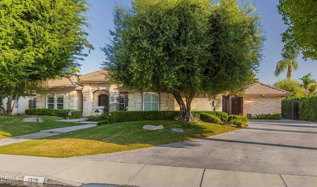 13115 Monarch Palm Ave, Bakersfield, CA 93314 - view of front of house featuring stone siding, a tiled roof, and driveway