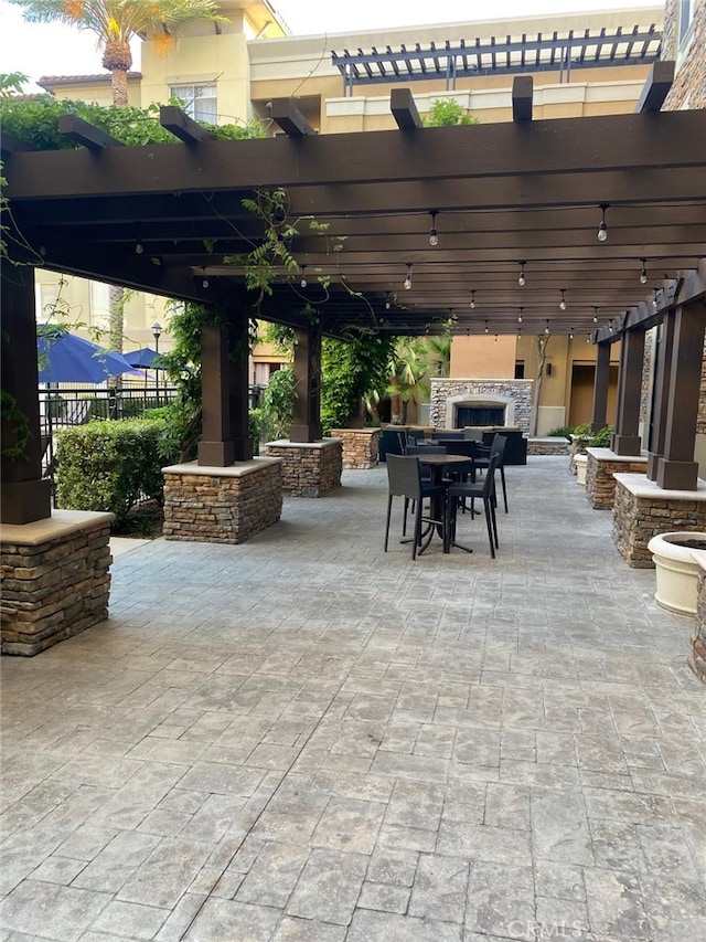 24595 Town Center Dr Unit 3407, Valencia, CA 91355 - view of patio featuring exterior fireplace, a pergola, and outdoor dining area