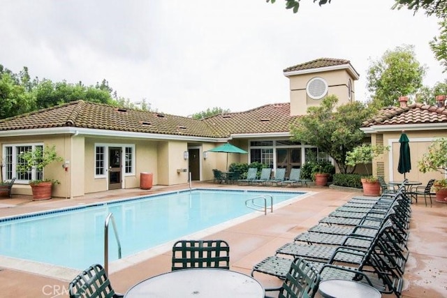 259 Gallery Way, Tustin, CA 92782 - rear view of house featuring a tiled roof, a patio, a community pool, and stucco siding