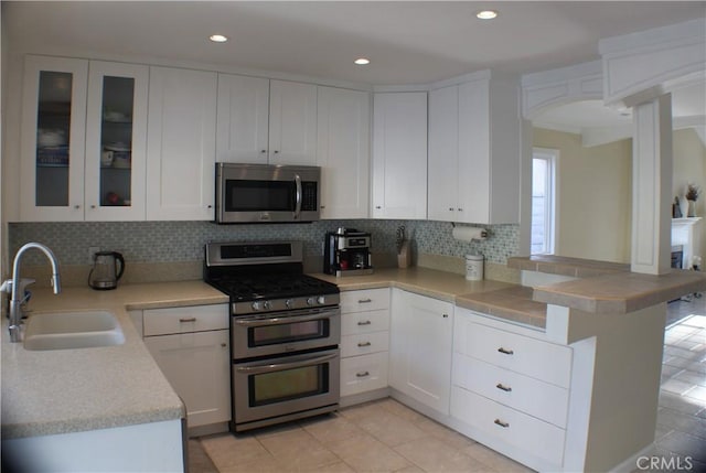 23266 Via Ronda, Mission Viejo, CA 92691 - kitchen featuring stainless steel appliances, a peninsula, light countertops, white cabinets, and decorative backsplash