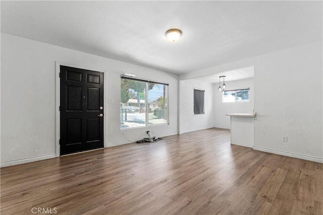 455 E Wilson St, Rialto, CA 92376 - unfurnished living room with wood finished floors and a chandelier