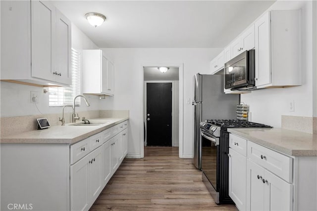 455 E Wilson St, Rialto, CA 92376 - kitchen featuring stainless steel gas range, light wood finished floors, and white cabinetry