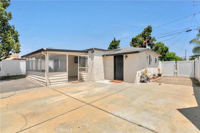 455 E Wilson St, Rialto, CA 92376 - back of property with a sunroom, stucco siding, a gate, and a patio area