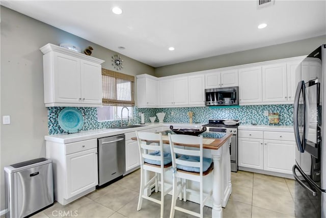 11543 Sky Pointe Dr, Desert Hot Springs, CA 92240 - kitchen with stainless steel appliances, light countertops, white cabinetry, backsplash, and recessed lighting