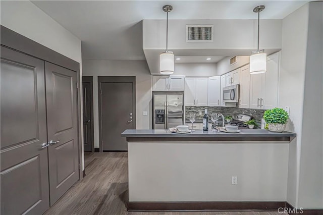 24595 Town Center Dr Unit 3205, Valencia, CA 91355 - kitchen featuring stainless steel appliances, white cabinets, dark wood-style floors, a peninsula, and decorative light fixtures