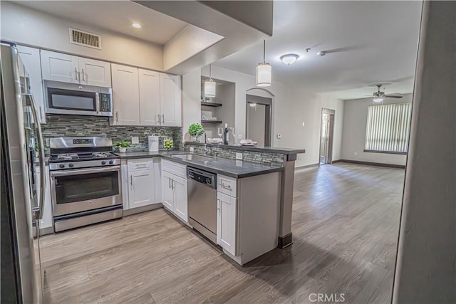 24595 Town Center Dr Unit 3205, Valencia, CA 91355 - kitchen with appliances with stainless steel finishes, a peninsula, dark countertops, open floor plan, and backsplash