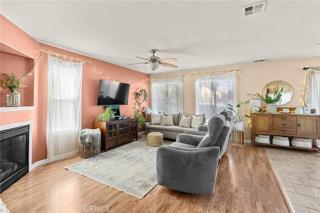 249 Colt Ln, Nipomo, CA 93444 - living area featuring a ceiling fan, a glass covered fireplace, and light wood-style floors