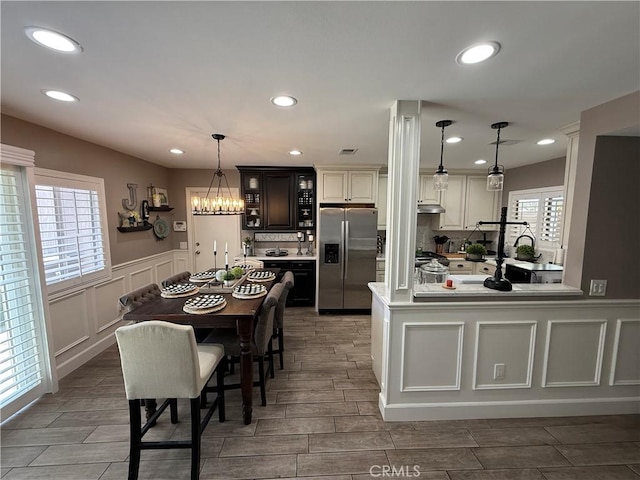 1053 Border Ave, Corona, CA 92882 - dining room with a wainscoted wall, a chandelier, wood tiled floors, recessed lighting, and a decorative wall