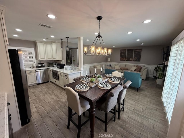 1053 Border Ave, Corona, CA 92882 - dining space featuring a chandelier, wainscoting, wood finished floors, recessed lighting, and a decorative wall