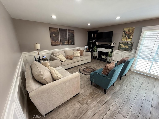 1053 Border Ave, Corona, CA 92882 - living area with a wainscoted wall, wood finished floors, a decorative wall, recessed lighting, and a fireplace