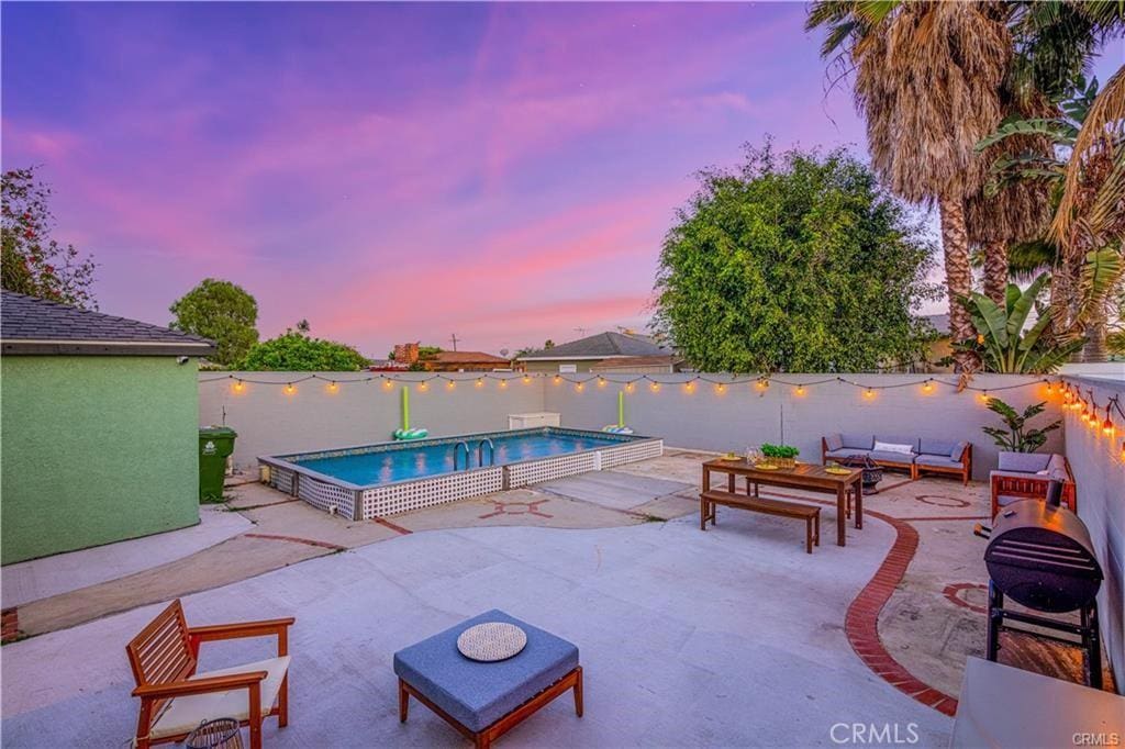 1381 W Summerland Ave, San Pedro, CA 90732 - pool at dusk with outdoor lounge area, a patio, and a fenced backyard