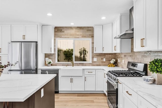 22461 Silver Spur, Lake Forest, CA 92630 - kitchen with appliances with stainless steel finishes, wall chimney range hood, white cabinets, light stone counters, and recessed lighting