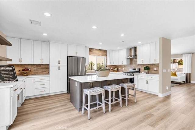 22461 Silver Spur, Lake Forest, CA 92630 - kitchen featuring wall chimney exhaust hood, appliances with stainless steel finishes, healthy amount of natural light, a center island, and recessed lighting