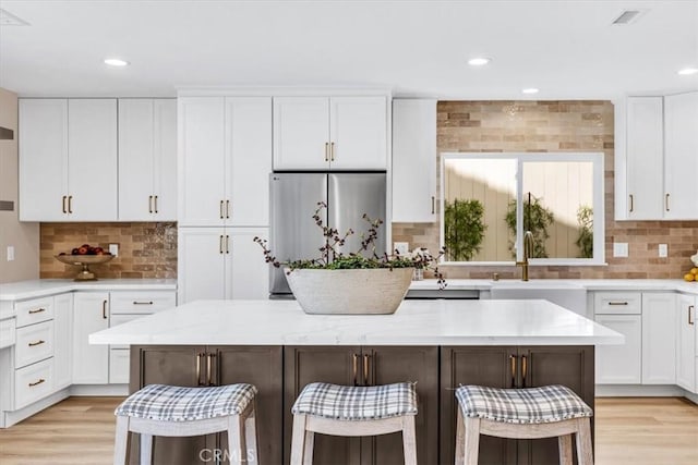 22461 Silver Spur, Lake Forest, CA 92630 - kitchen featuring stainless steel fridge, tasteful backsplash, light wood-style flooring, white cabinets, and recessed lighting