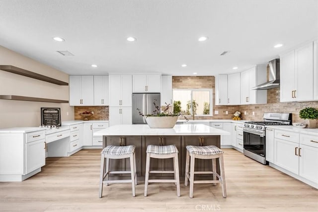 22461 Silver Spur, Lake Forest, CA 92630 - kitchen with wall chimney exhaust hood, stainless steel appliances, a breakfast bar area, a kitchen island, and white cabinets