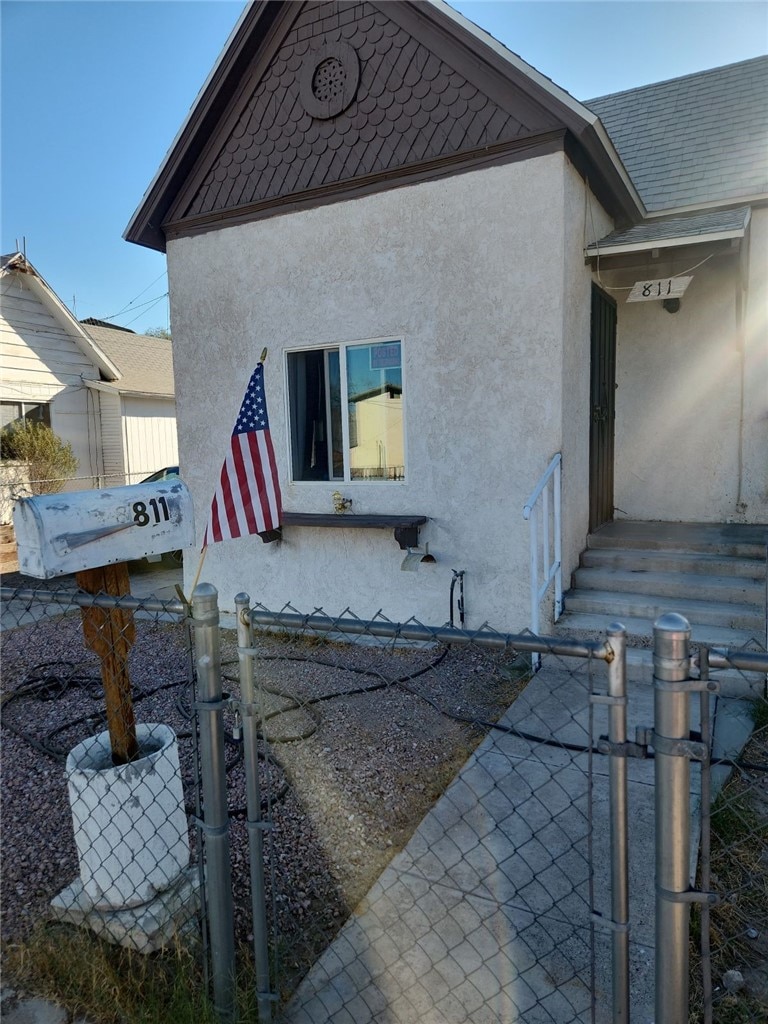 811 4th St, Needles, CA 92363 - view of property exterior featuring stucco siding and a gate