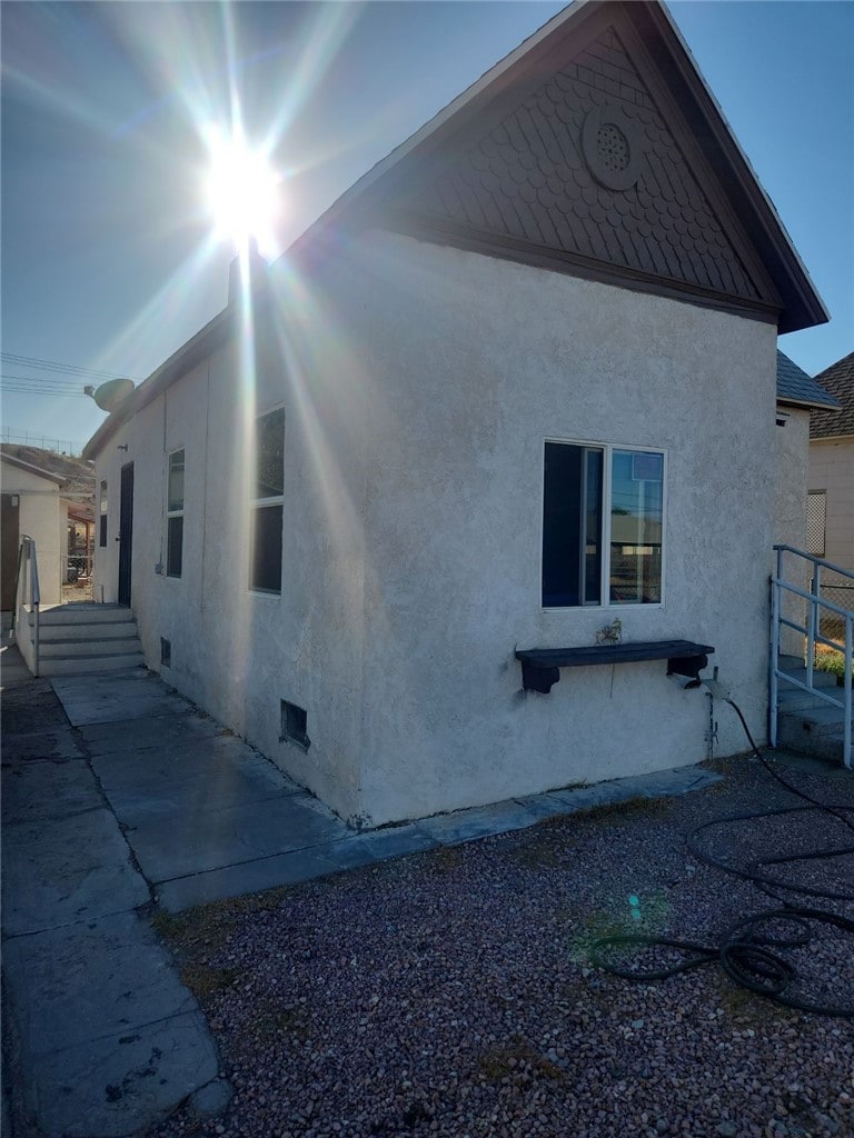 811 4th St, Needles, CA 92363 - view of home's exterior with stucco siding and crawl space