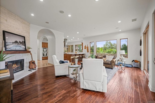 4149 Manchester Ave, Encinitas, CA 92024 - living area with wood finished floors, a stone fireplace, recessed lighting, and arched walkways