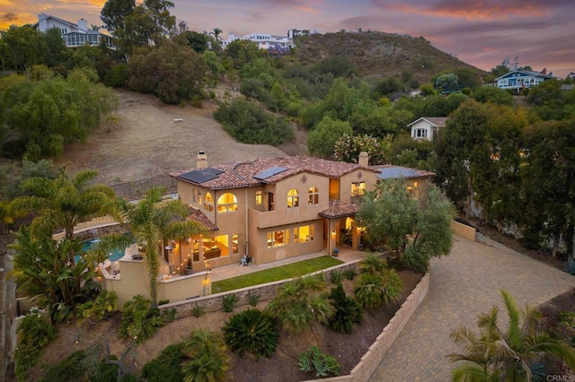 4149 Manchester Ave, Encinitas, CA 92024 - back of property featuring a chimney, solar panels, stucco siding, a fenced backyard, and a patio area