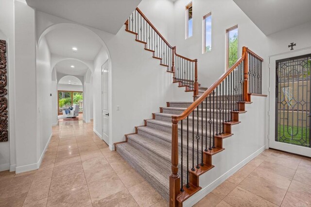 4149 Manchester Ave, Encinitas, CA 92024 - staircase with arched walkways, a high ceiling, and recessed lighting