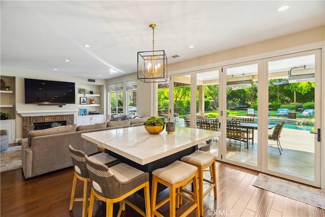 2937 Arboridge Ct, Fullerton, CA 92835 - dining room with a brick fireplace, hardwood / wood-style flooring, a chandelier, and recessed lighting