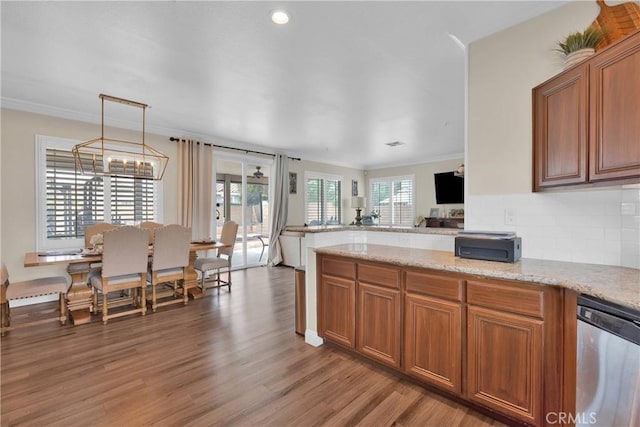 16315 Yorba Linda Ln, Fontana, CA 92336 - kitchen with stainless steel dishwasher, healthy amount of natural light, brown cabinets, ornamental molding, and recessed lighting