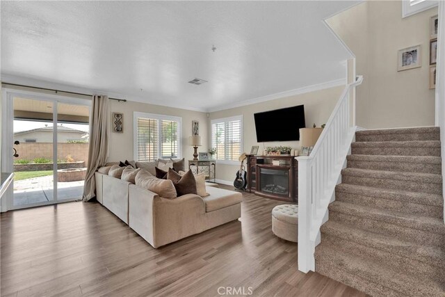 16315 Yorba Linda Ln, Fontana, CA 92336 - living room featuring wood finished floors, a glass covered fireplace, crown molding, and stairway