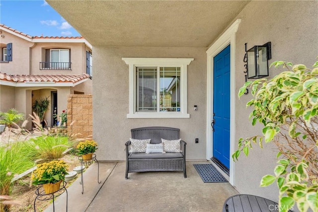 16315 Yorba Linda Ln, Fontana, CA 92336 - view of exterior entry with stucco siding, a patio area, and a tiled roof