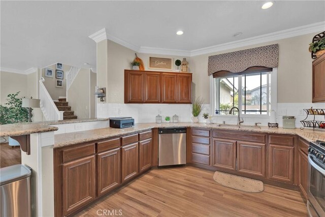 16315 Yorba Linda Ln, Fontana, CA 92336 - kitchen with stainless steel appliances, a peninsula, tasteful backsplash, light stone countertops, and light wood-style flooring