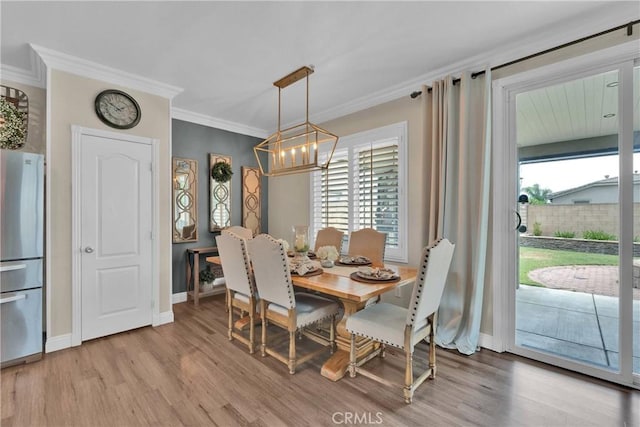 16315 Yorba Linda Ln, Fontana, CA 92336 - dining area with a chandelier, light wood-type flooring, plenty of natural light, and ornamental molding