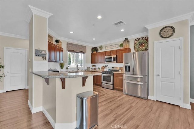 16315 Yorba Linda Ln, Fontana, CA 92336 - kitchen featuring appliances with stainless steel finishes, a peninsula, a breakfast bar area, light wood finished floors, and light stone counters